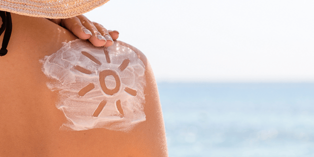 A persons back with a sun drawn into suncream