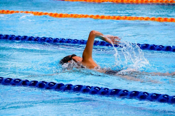 A young man is swimming in the pool