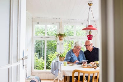 Senior couple at home looking at options on a tablet