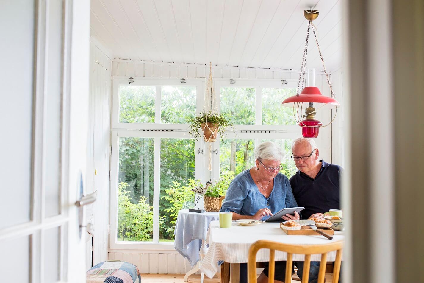 Senior couple in their home looking at a tablet (1)