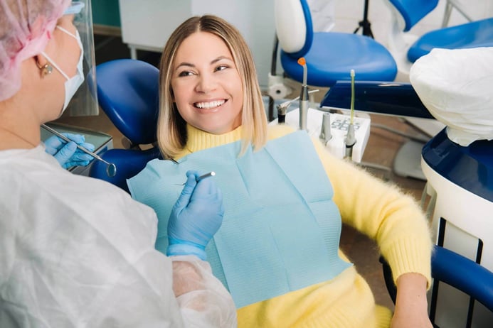 Young girl smiles at the dentist and looks at her