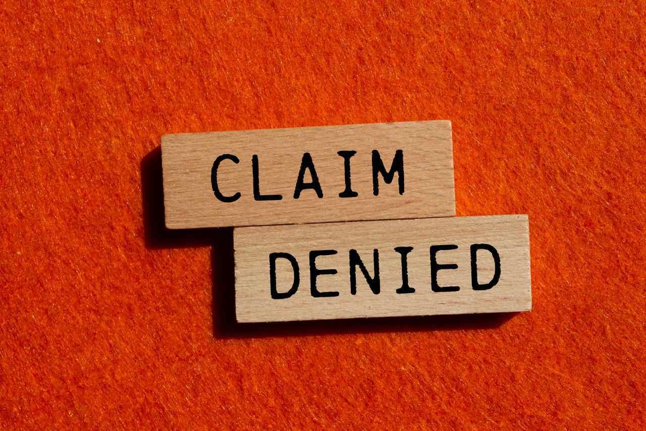 Claim denied message written on wooden blocks with orange background