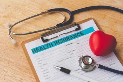 health insurance form with a pen and a stethoscope
