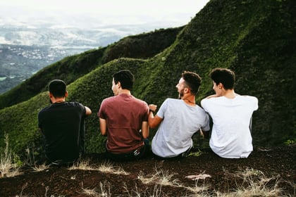 Group of men sat outdoors in nature